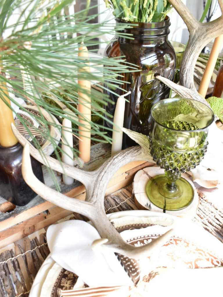 antler on top of rustic wood candleholder with tapers