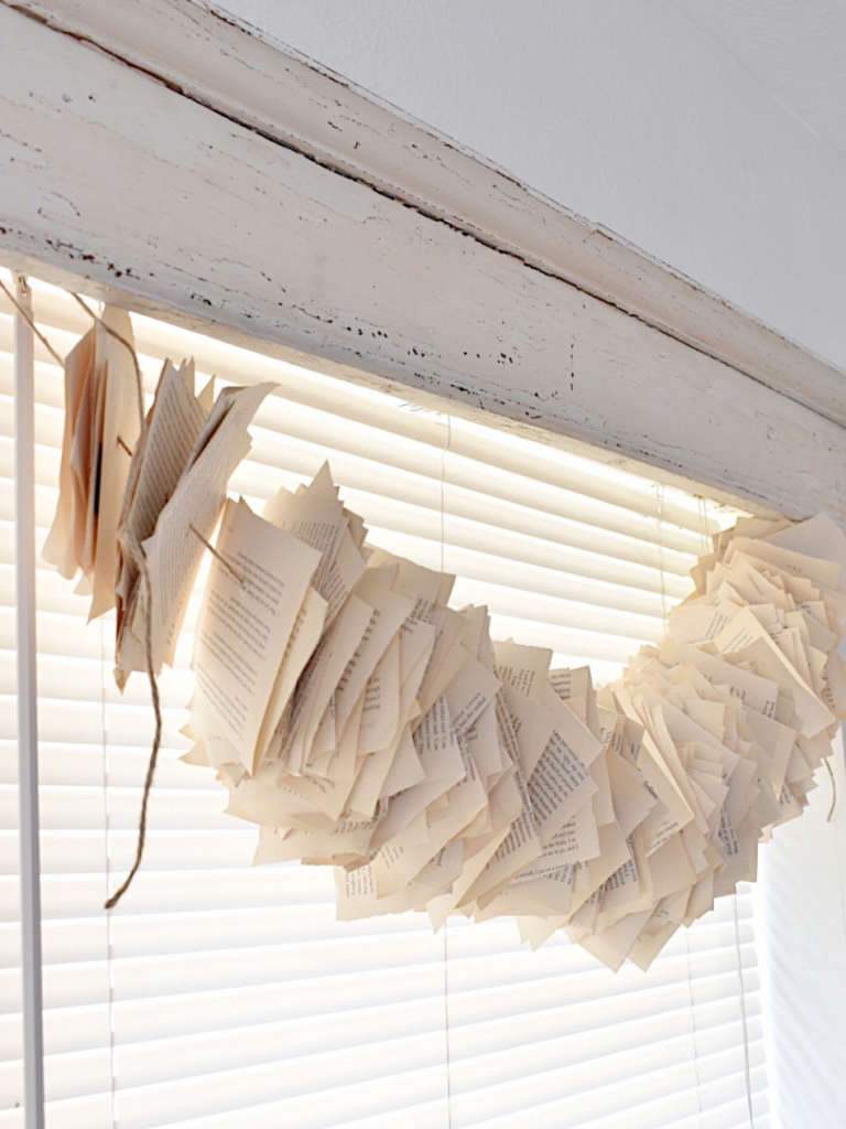 garland made from vintage book pages and hanging in front of window
