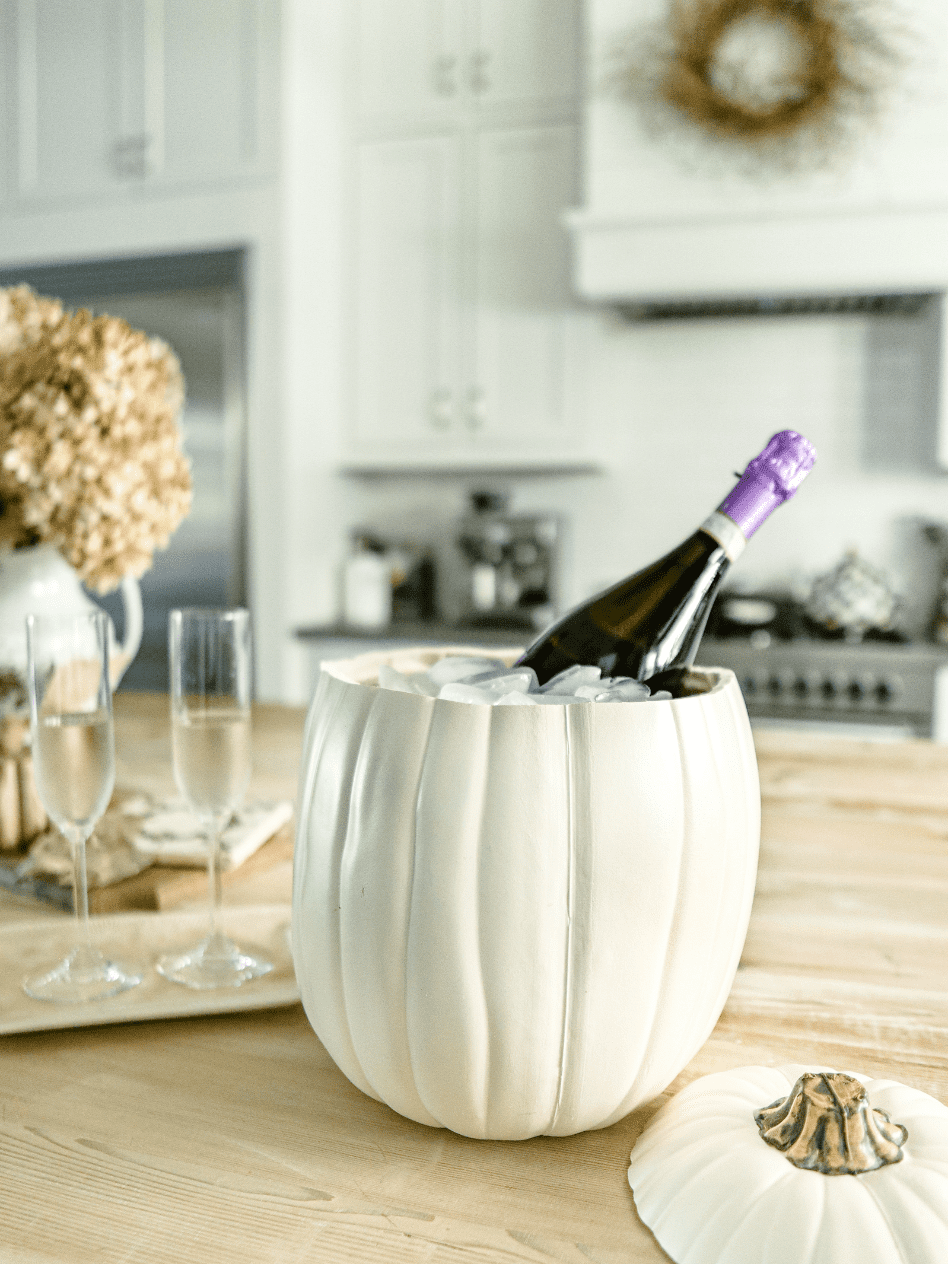 faux pumpkin ice bucket filled with ice and a bottle of prosecco