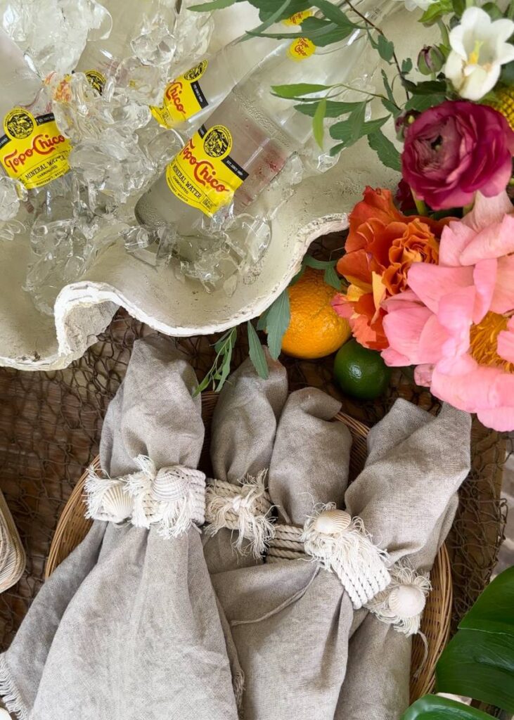 large seashell filled with ice for drinks and linen napkins with seashell embellished napkin ring