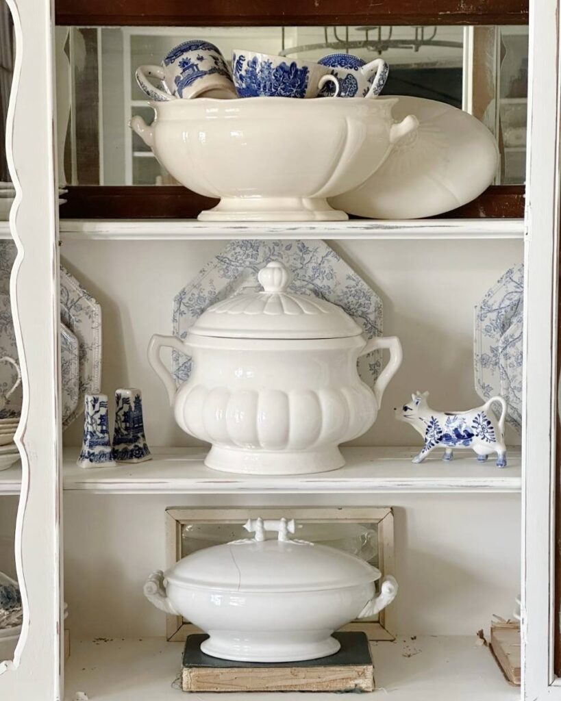 china cabinet with white dishes and blue transferware dished displayed